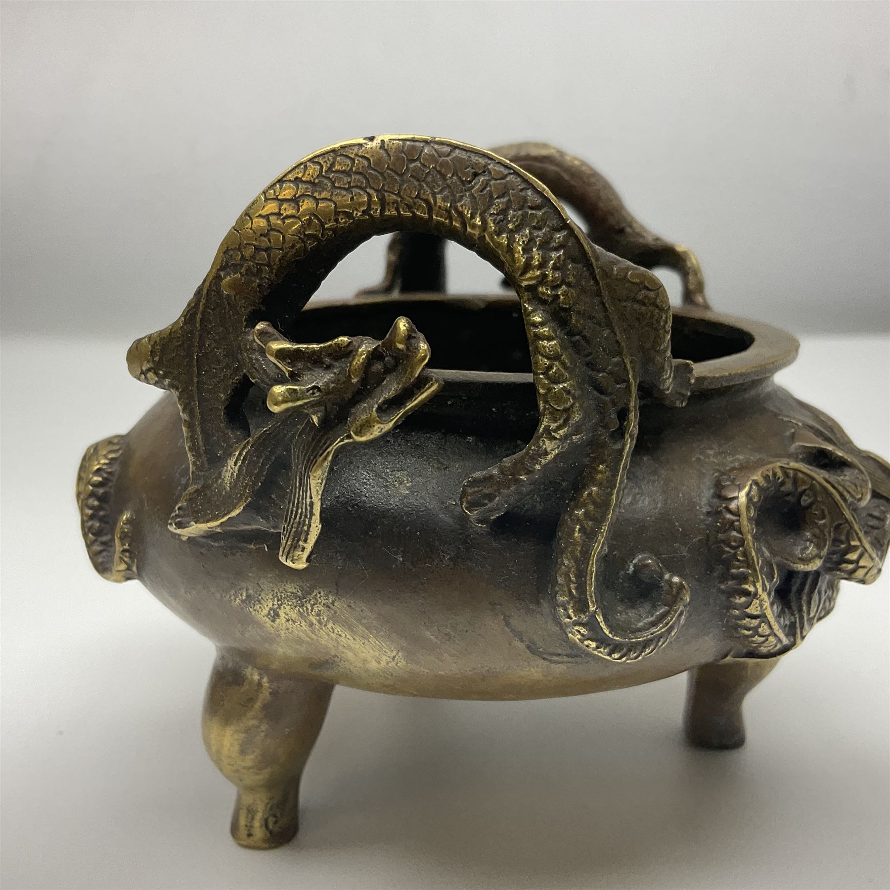 Chinese cast brass censer, with applied dragon twin handles and decoration, raised upon three feet with character mark beneath, D12cm H9.5cm