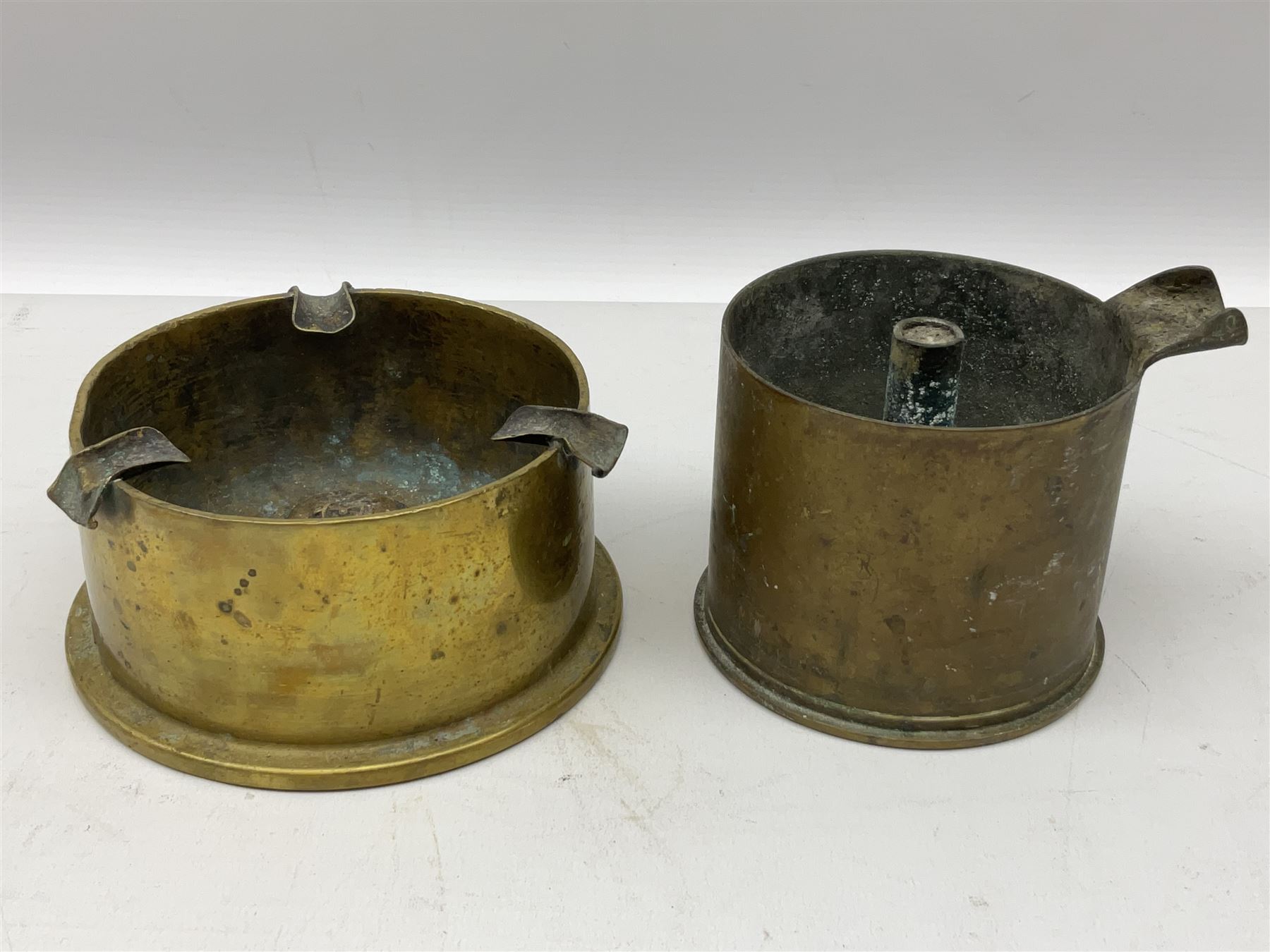 Trench Art - three WW2 brass shell case ashtrays, one mounted with Royal Artillery cap badge and button and one mounted with RA button; together with a pair of place name holders each formed from a Royal Artillery cap badge (5)