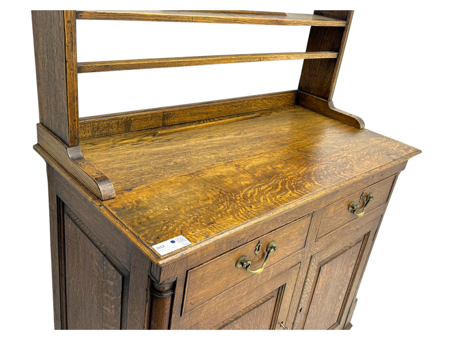 19th century and later oak dresser, moulding cornice a pierced and shaped frieze, over two open plate shelves above a base fitted with two drawers with brass swan neck handles, over panelled twin cupboard with single shelf, cantered corners on bracket feet