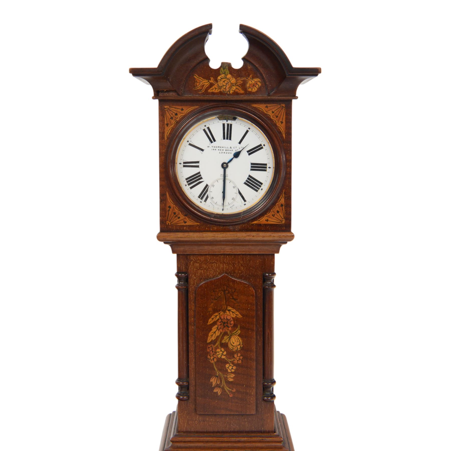Edwardian mahogany and marquetry miniature longcase clock, the case with ogee top, over arched door flanked by turned columns, the base, door and top with classical urn and floral marquetry detail, housing goliath pocket watch, the white enamel dial with Roman numerals, chapter ring and subsidiary dial, and marked W. Thornhill & Co Ltd 144 New Bond St London, H38cm