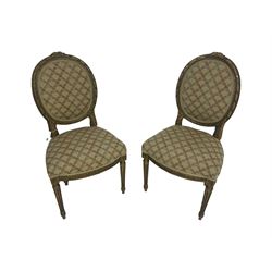 Pair 19th century French giltwood drawing room chairs, the oval back frame with acanthus leaf decorated ribbon twist carving, back and sprung seat upholstered in foliate patterned fabric, apron carved with guilloche decoration, raised on fluted supports