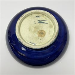 A large Moorcroft bowl decorated in the Iris pattern upon a dark blue ground, with impressed and painted marks beneath, and paper label detailed Potters to the late Queen Mary, D30.5cm.