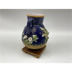 Minton majolica vase, the squat body with twin handles, with part osier moulding and applied Spring flowers against a cobalt blue ground, upon integral square base, impressed beneath Minton 1316, H16.5cm