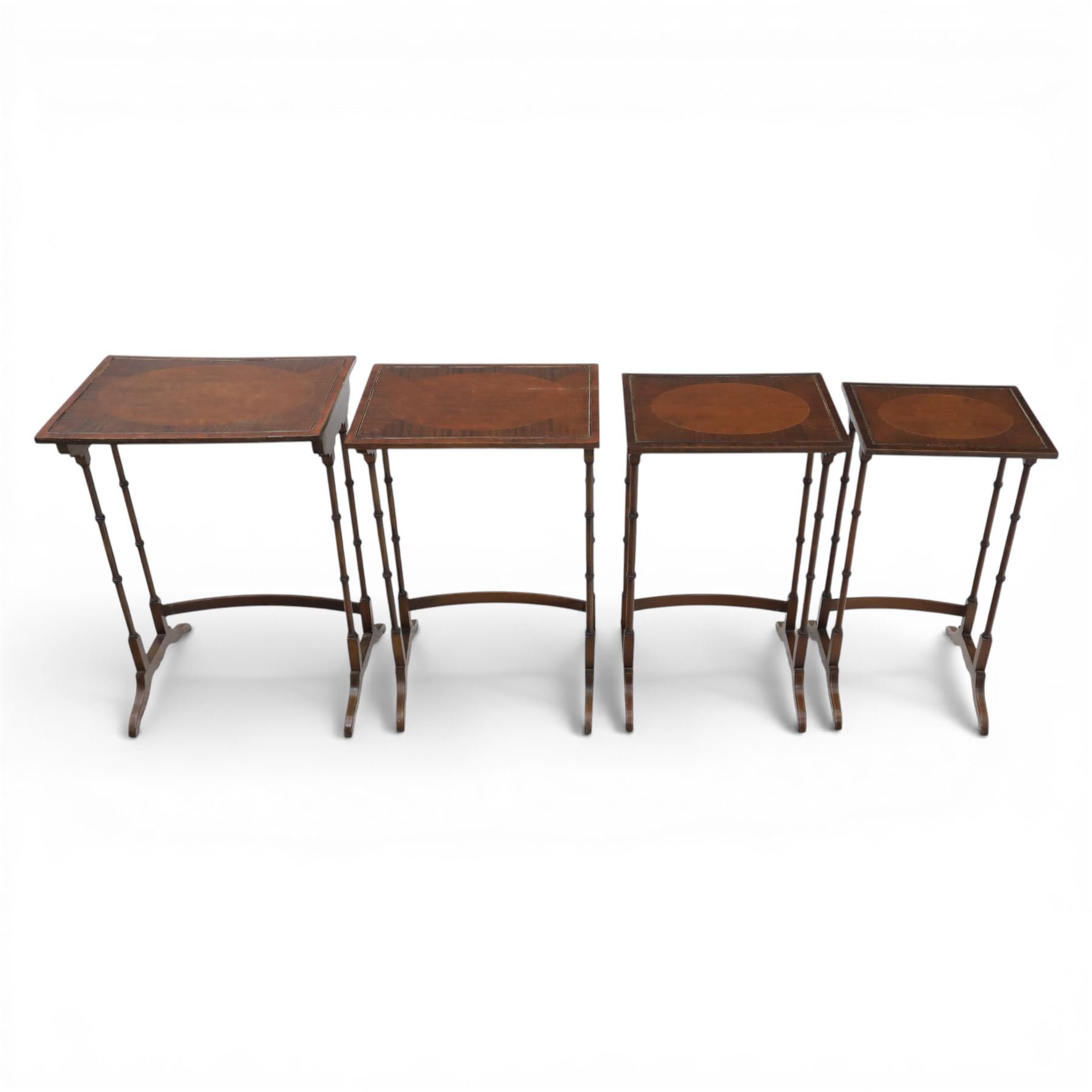 20th century mahogany quartetto nest of tables, the rectangular tops with oval inlay, upon turned knopped supports, united by a curved stretcher, raised upon outswept feet