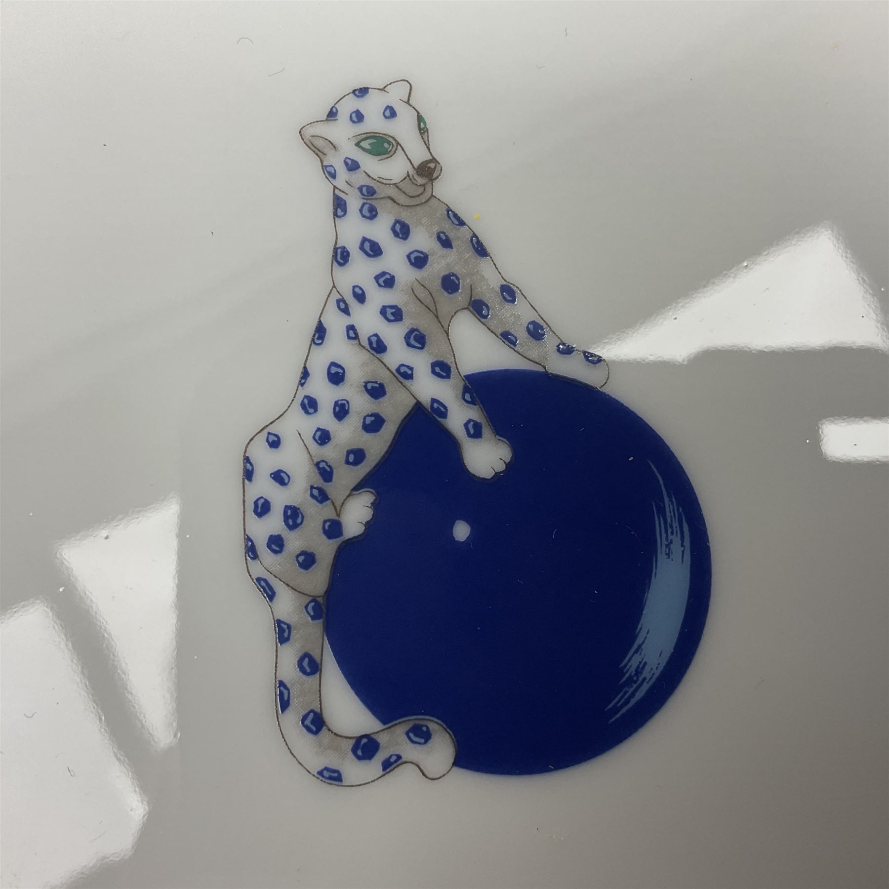 Limoges for Cartier, ceramic trinket dish, of rectangular form with rounded corners, decorated to centre with leopard upon a blue ball, with blue and gilt rim, with printed mark beneath, in original box, H15.5cm, W21cm