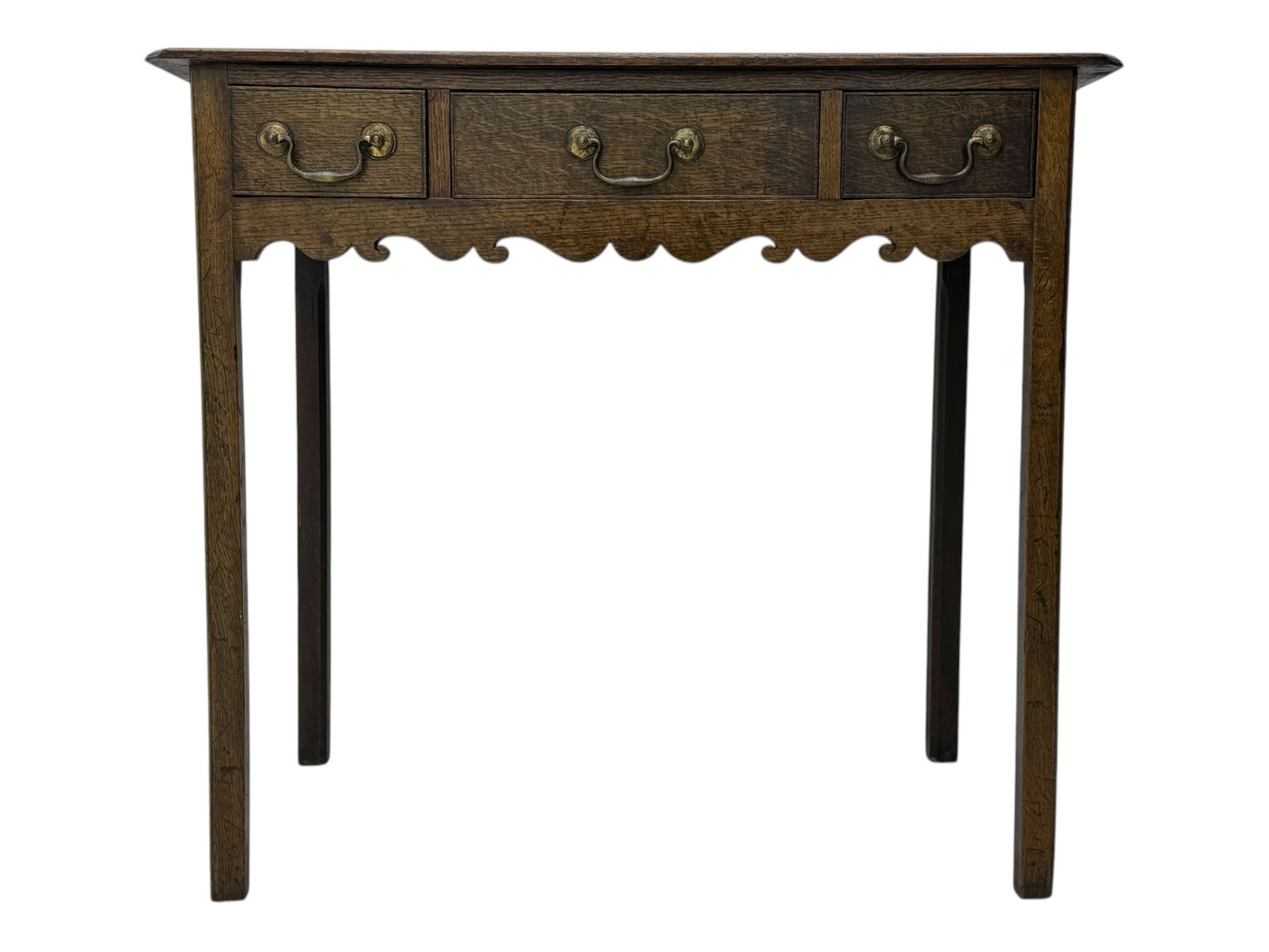18th century oak lowboy, rectangular moulded top over three frieze drawers with brass swing handles, scalloped apron, on slender square section supports