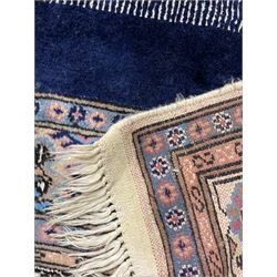 Indo-Persian indigo ground rug, the field depicting a rug with floral medallion and spandrels, enclosed within multiple floral pattern border bands