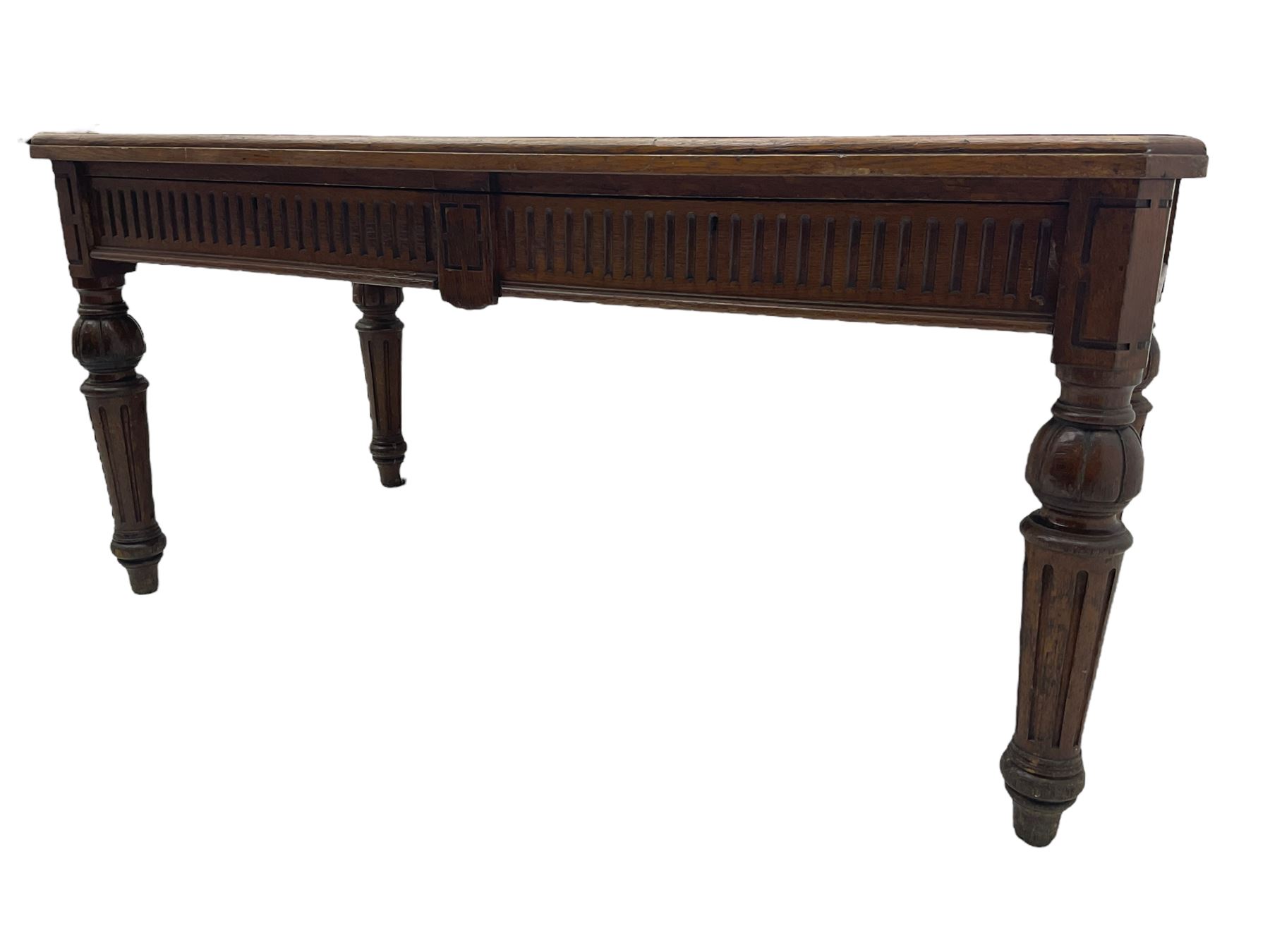 Late 19th century oak library table, moulded rectangular top with canted corners, fitted with two frieze drawers with fluted facias, on lobe carved and fluted turned supports 