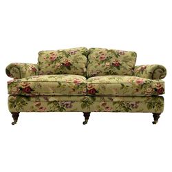 Hancock & Moore - two-seat sofa, upholstered in pale green ground fabric decorated with floral pattern, traditional shape with rolled arms and arched back, on turned front feet with brass cups and castors 