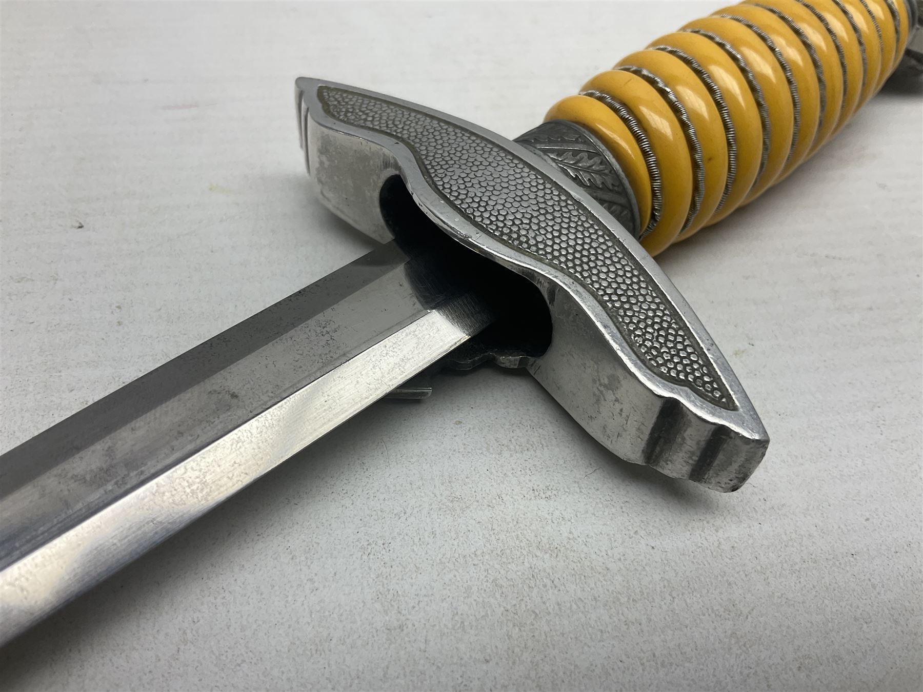 WW2 German Luftwaffe 2nd Pattern Officers dress dagger, with unmarked 25.5cm double edged steel blade, wire-bound pale orange/yellow celluloid grip, globular  pommel with oak leaves and traces of gilding, Luftwaffe eagle cross guard; in beaded scabbard with two suspension rings L43cm overall