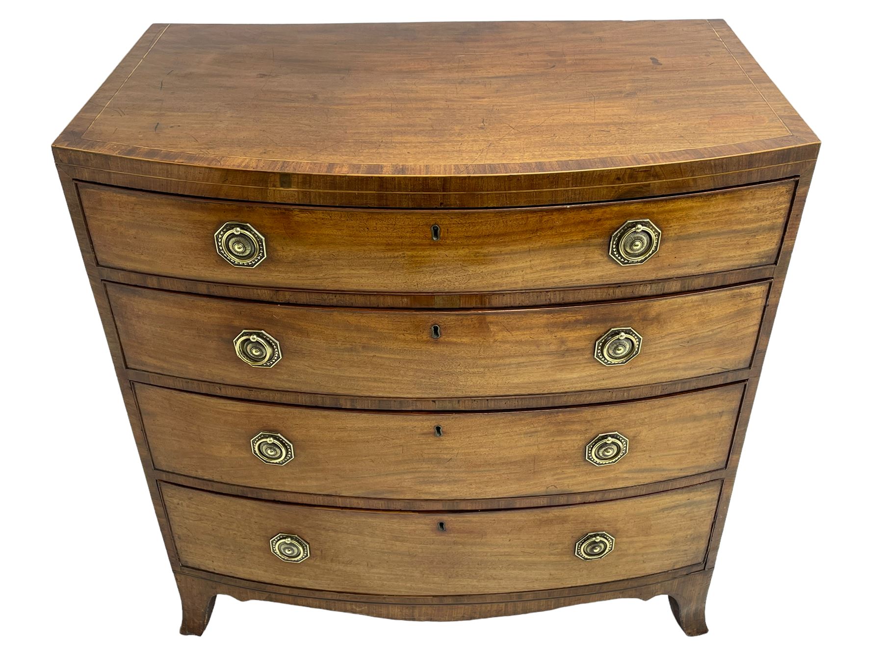 George III inlaid mahogany bow-front chest, fitted with four graduating drawers, octagonal plate and loop handles, shaped apron and splayed bracket feet