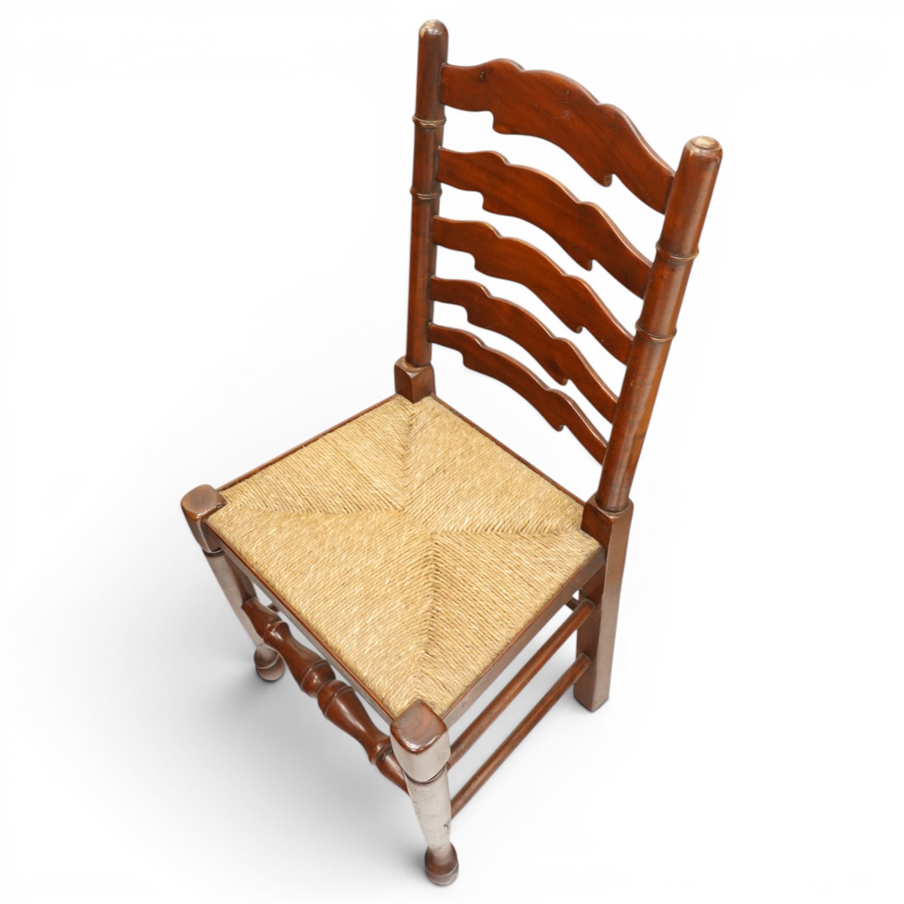 Set of six Lancashire country ladderback dining chairs with rush seats, raised on tapering supports with swell-turned stretcher