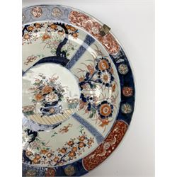 Japanese Imari charger, late 19th/early 20th century, decorated with a central circular panel of flowers arranged in twin handled vase, surrounded by four lattice and larger panels painted with floral sprays and trees and stylised foliate border, W37cm
