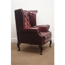  Pair George lll style wingback armchairs, upholstered in deep buttoned oxblood red leather, on cabriole legs, W90cm, H104cm, D75cm (2)  