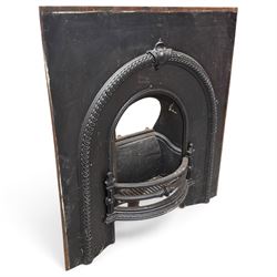 Late Victorian black-painted cast iron fireplace, the arched surround with anthemion carto...