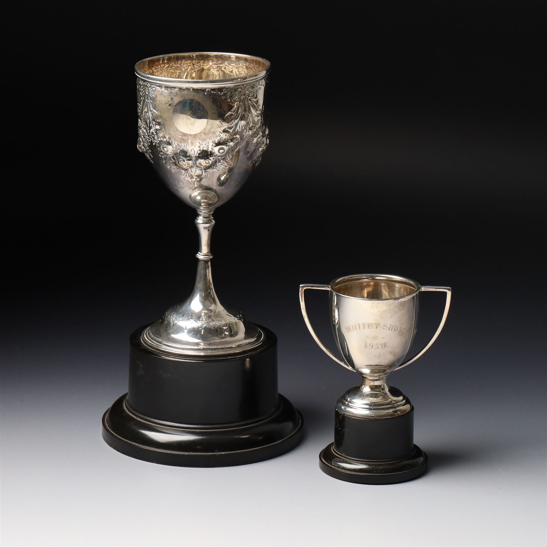 Victorian silver cup with embossed decoration on a plastic base, height of cup 16cm Birmingham 1868 and a small silver challenge cup 'Whitby Show 1950'