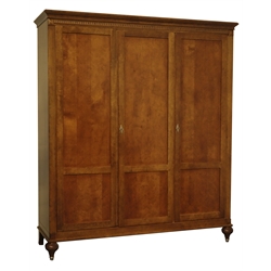  Quality reproduction walnut triple wardrobe, projecting cornice above dentil frieze, three full length panelled doors, interior fitted with adjustable shelves and handing rail, turned feet, W192cm, H221cm, D62cm  