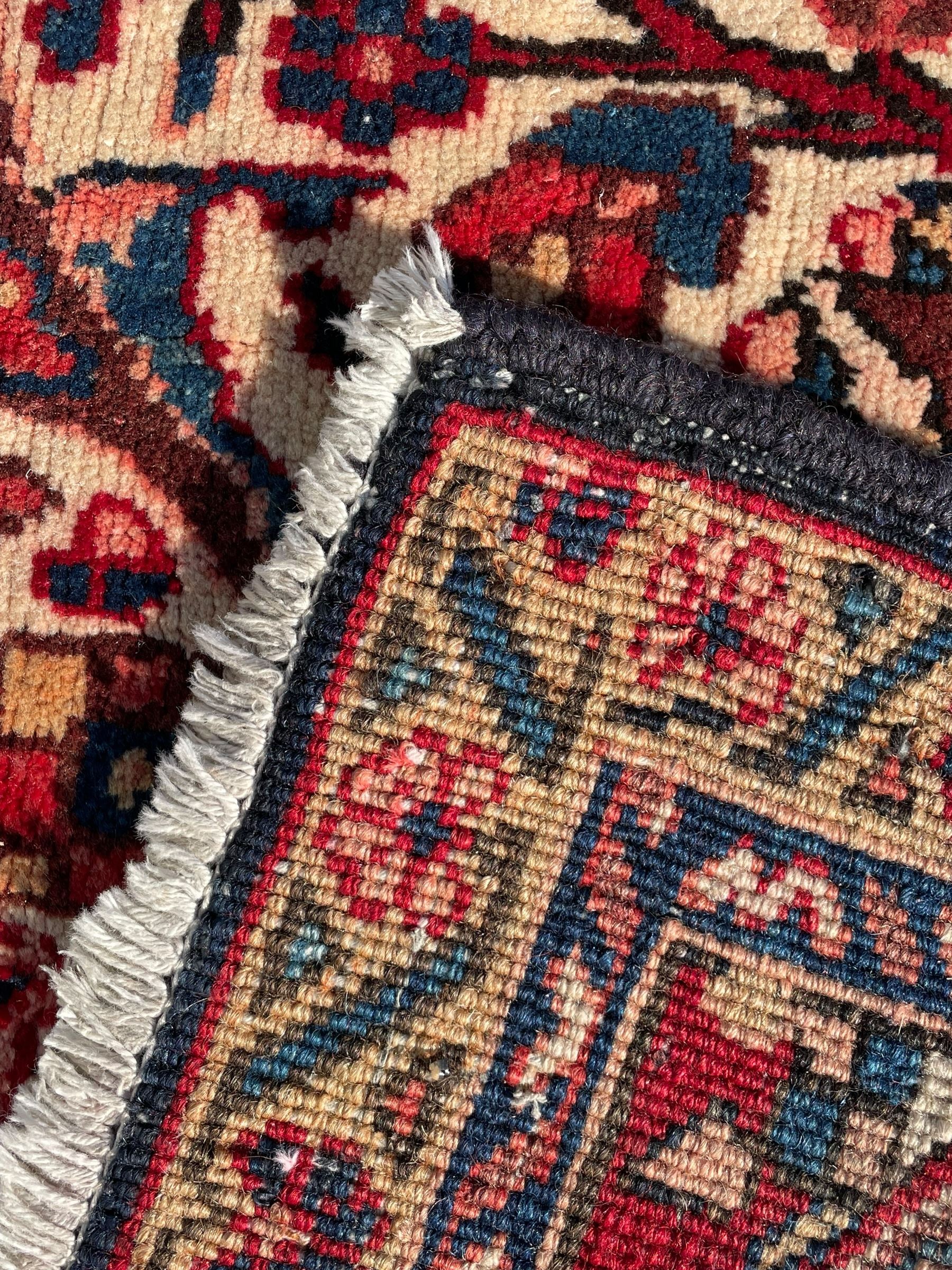 Persian Hamadan indigo and red ground carpet, large central medallion decorated with projecting palmette motifs, the surrounding field decorated with trailing branches and flower heads, crimson ground border decorated with stylised plant motifs, within floral pattern guard stripes 