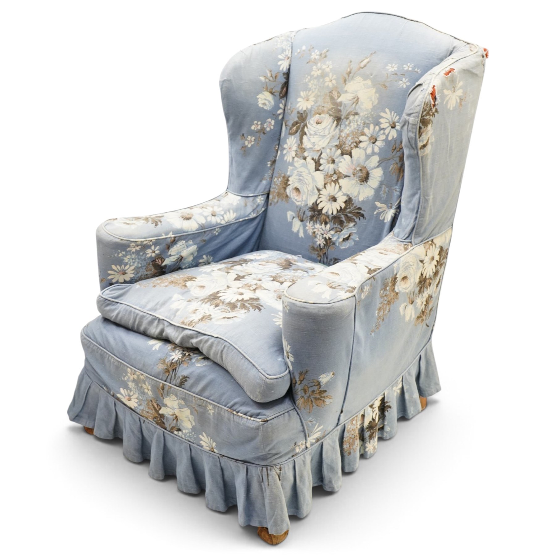 Pair of Queen Anne wingback armchairs, high back over out-swept arms, raised on ball-and-claw feet, upholstered in sky-blue ground floral chintz loose upholstery with pleated skirt and squab cushion