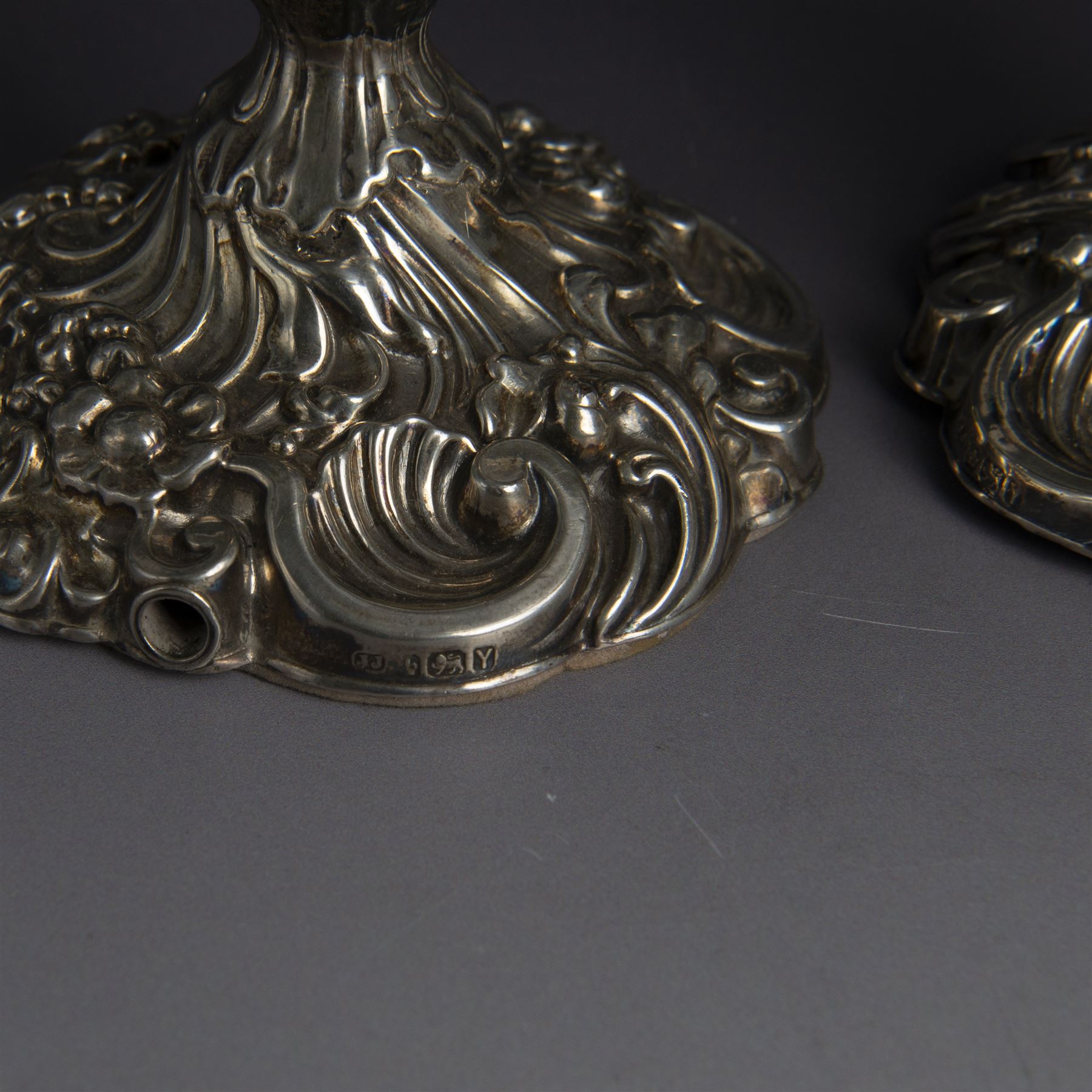 Pair of late Victorian silver candlesticks, each embossed wth floral, foliate and scrolling decoration, with removable sconces and upon a weighted embossed base, hallmarked Jenkins & Timm, Sheffiled 1891, H20cm