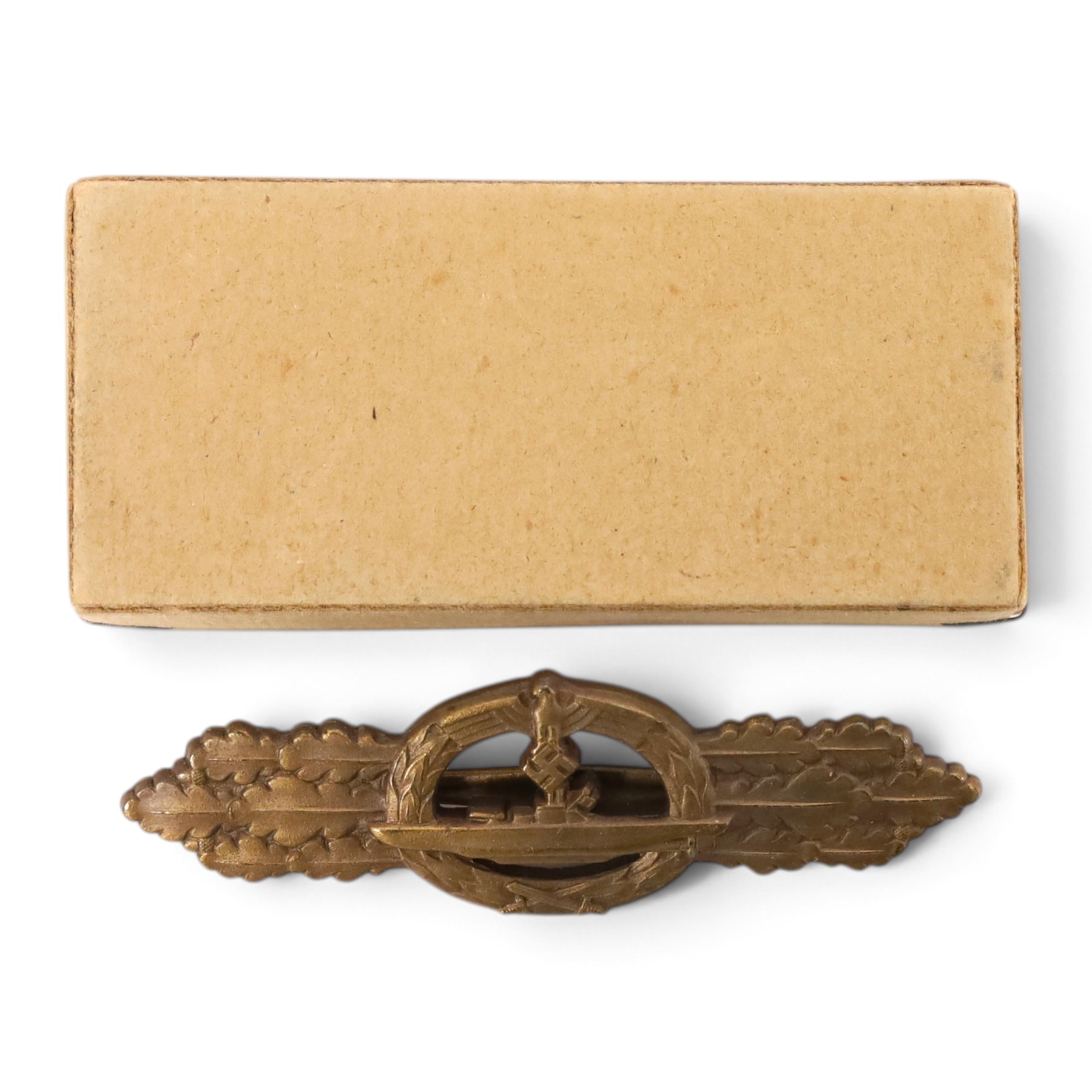 WWII German Kriegsmarine U-Boat combat clasp in bronze by Schwerin Berlin, with the original horizontal pin and catch fixing, makers mark to the reverse “ENTWURF PEEKHAUS AUSF SCHWERIN BERLIN 68” in original packaging