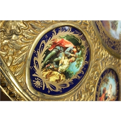  Louis XVl style gilt metal mounted ebonised centre table, the embossed circular top inset with one circular and ten oval Sevres style plaques decorated with Lovers in Garden landscapes, on urn shaped column with rams head and scroll supports, D116cm, H90cm  