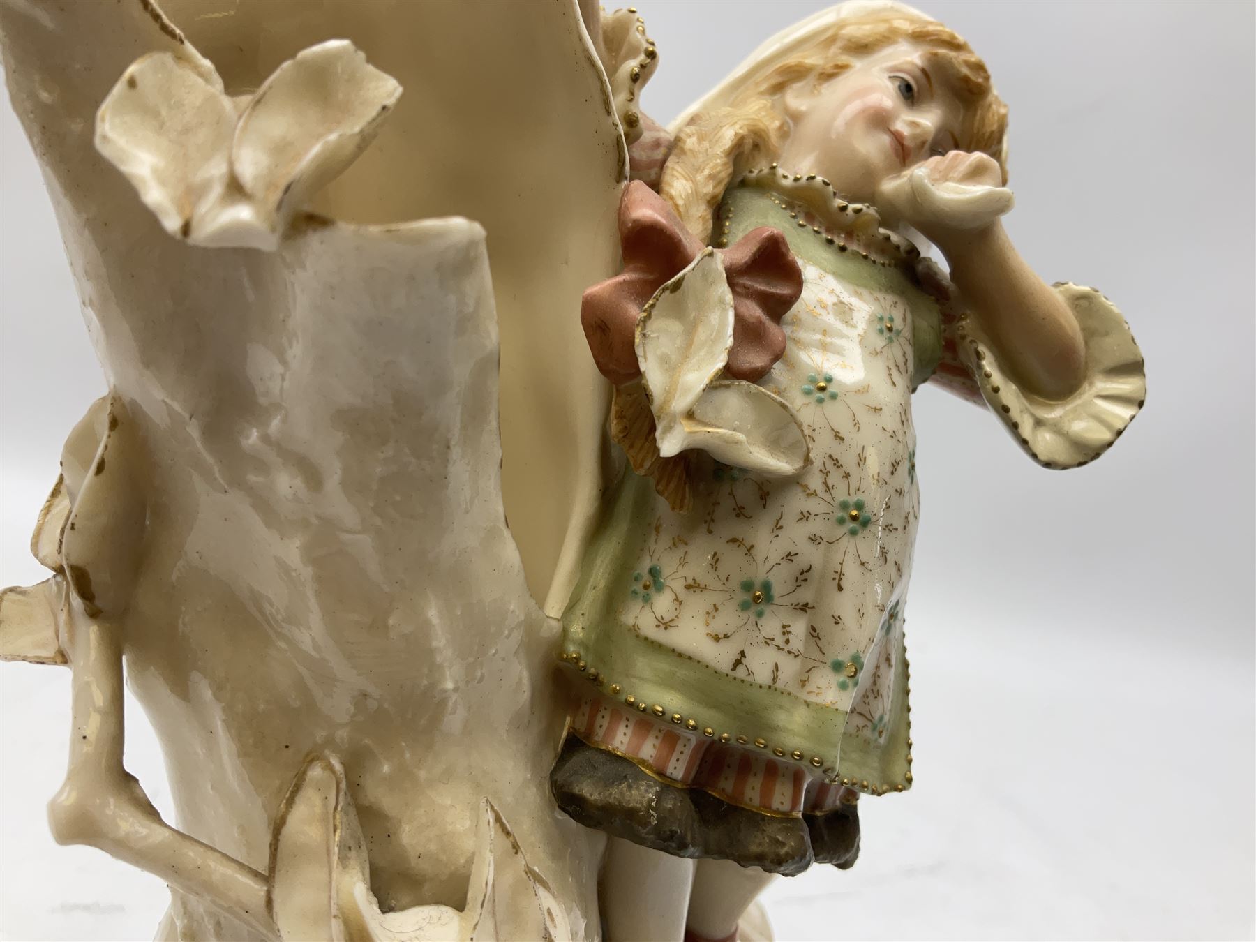 Late 19th century continental spill vase as a young girl standing beside an open tree trunk H21cm; and three German bisque figures (4)