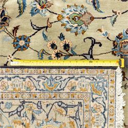 Persian Kashan rug, cream ground decorated with an all-over pattern of interlaced floral stems, rosettes and palmettes in blue, gold and rust tones, framed by layered floral borders, woven in the Kashan region of Iran