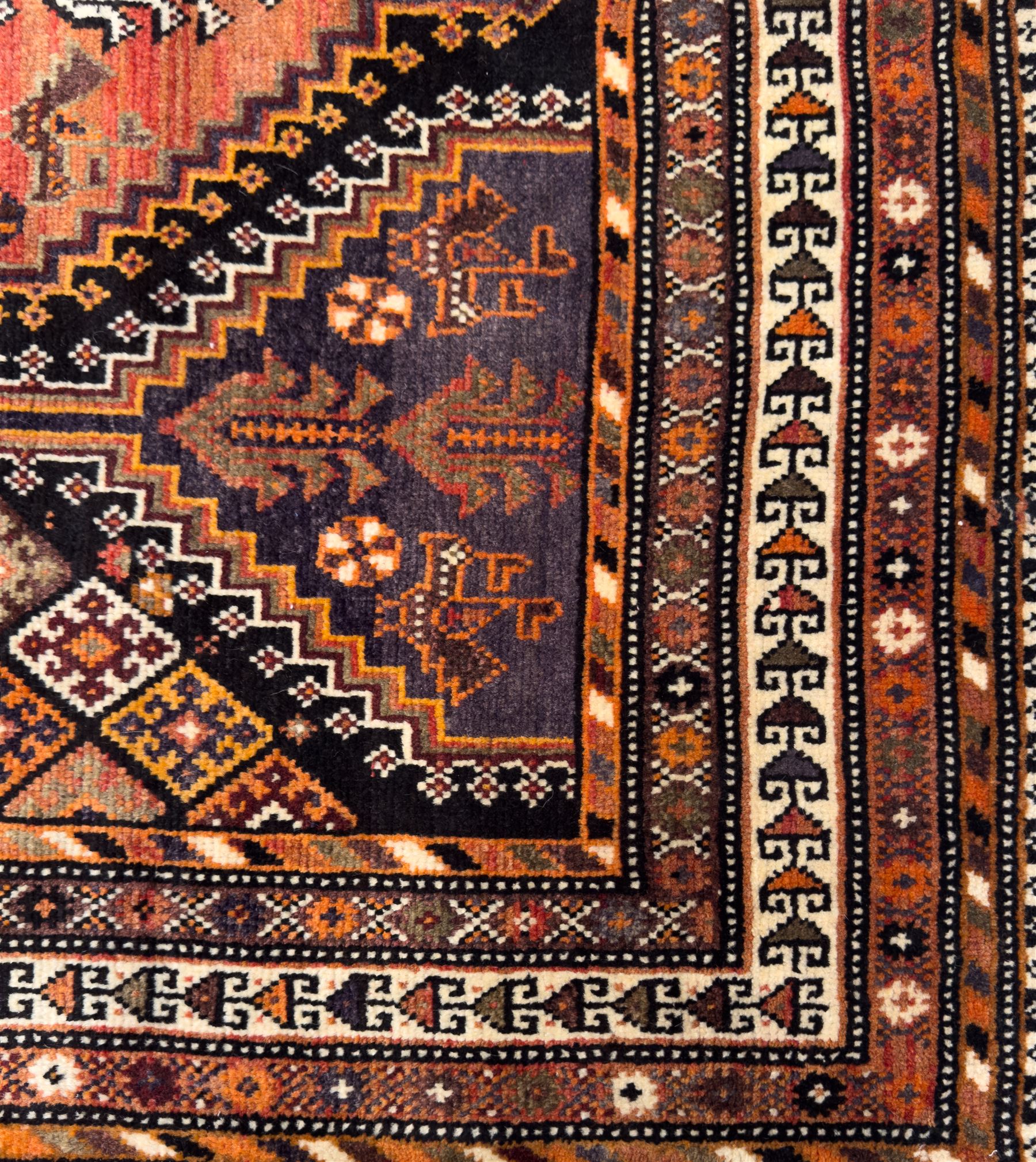Southwestern Persian Qashqai hand-knotted carpet, the field with a lattice of hexagonal medallions in rust, indigo, and ochre, each containing stylised tree and floral motifs, flanked by lozenge panels with geometric designs, enclosed by multiple borders with rosettes and leaf motifs