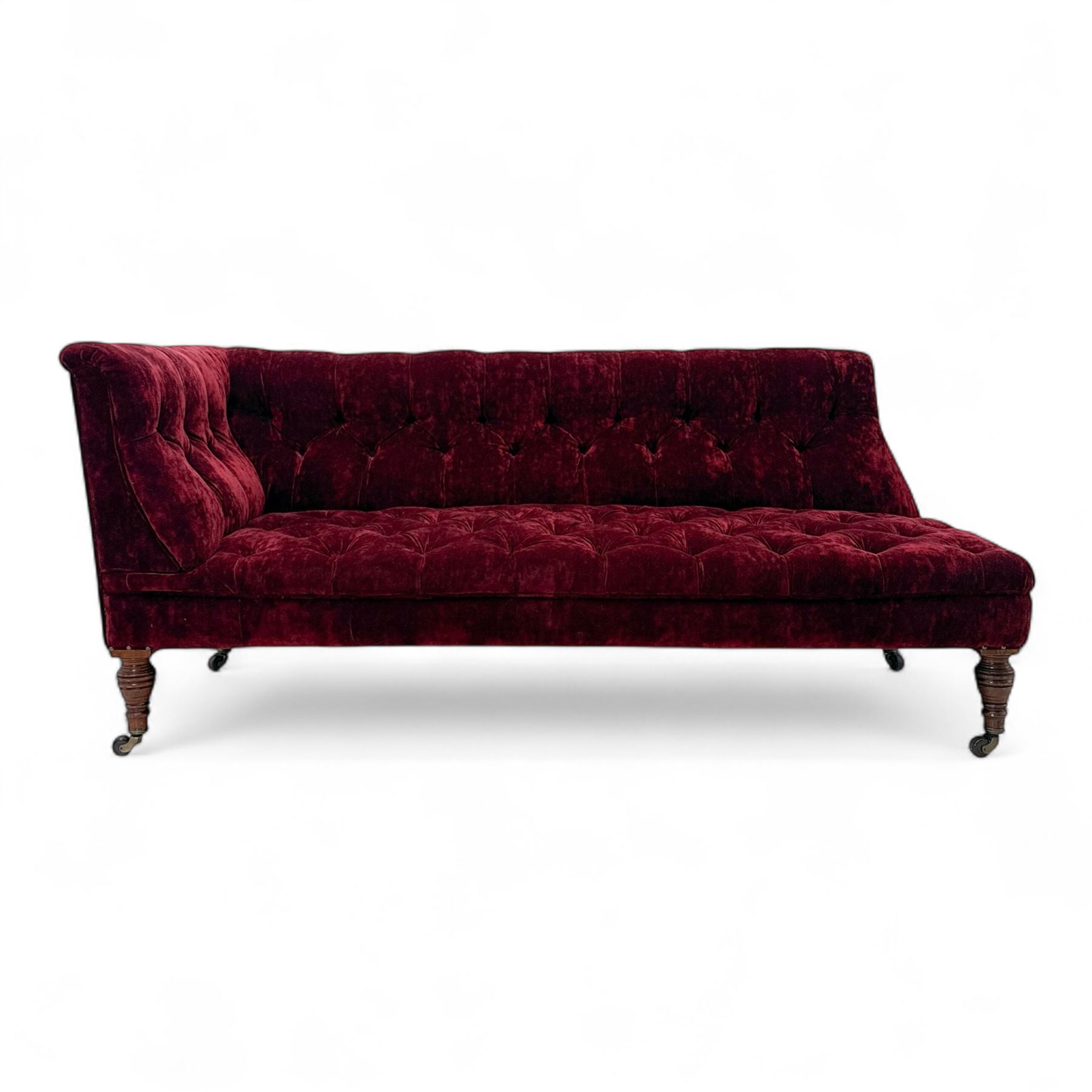 Late Victorian upholstered chaise longue in buttoned red velvet, shaped backrest, on turned walnut legs 
