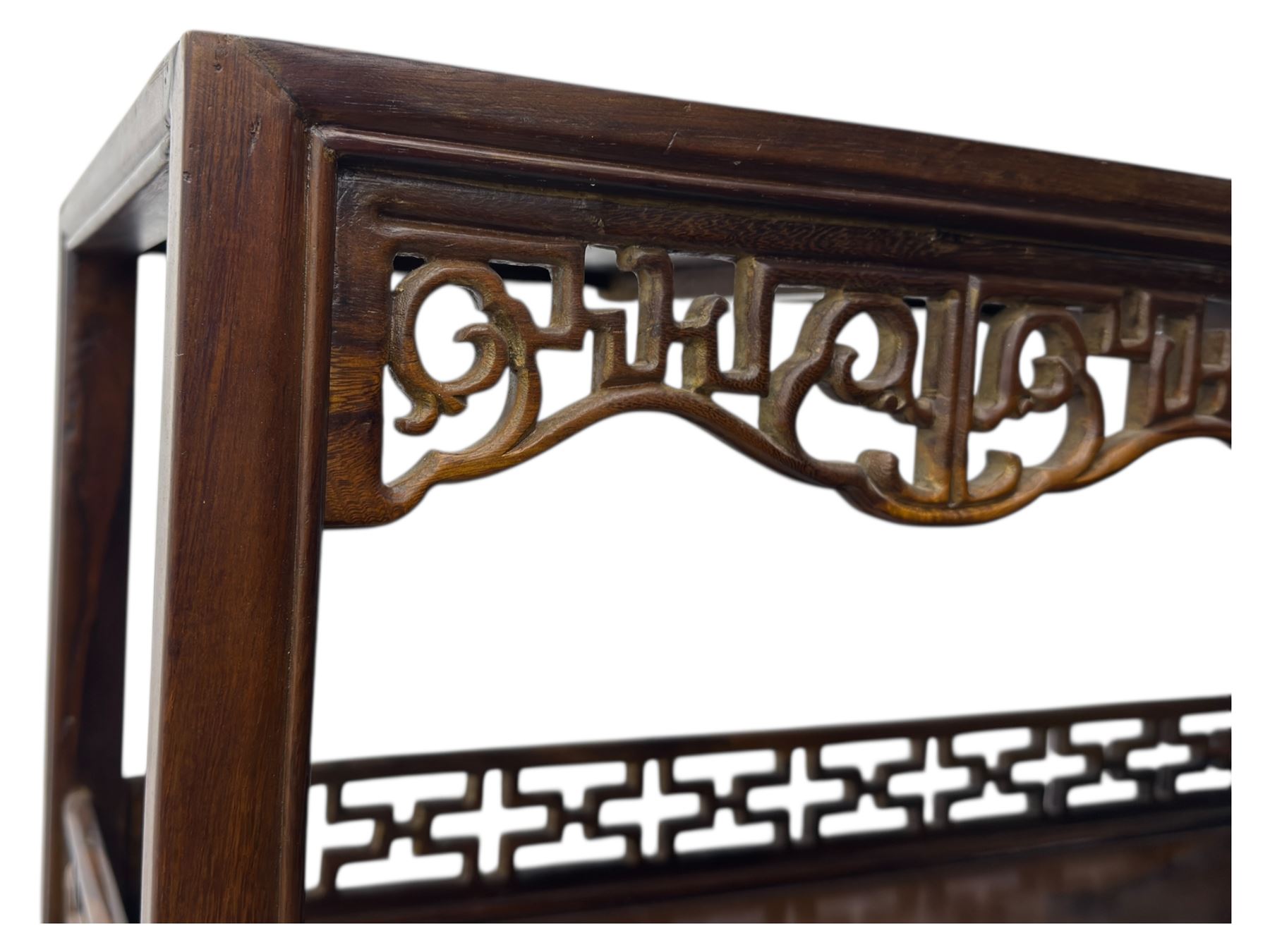 Early 20th century Chinese hardwood display étagère bookcase, the rectangular open tiered frame with pierced frieze and geometric openwork gallery to each shelf, fitted with two short drawers carved with stylised lotus motifs, supported on square uprights with pierced apron and integral gallery rails