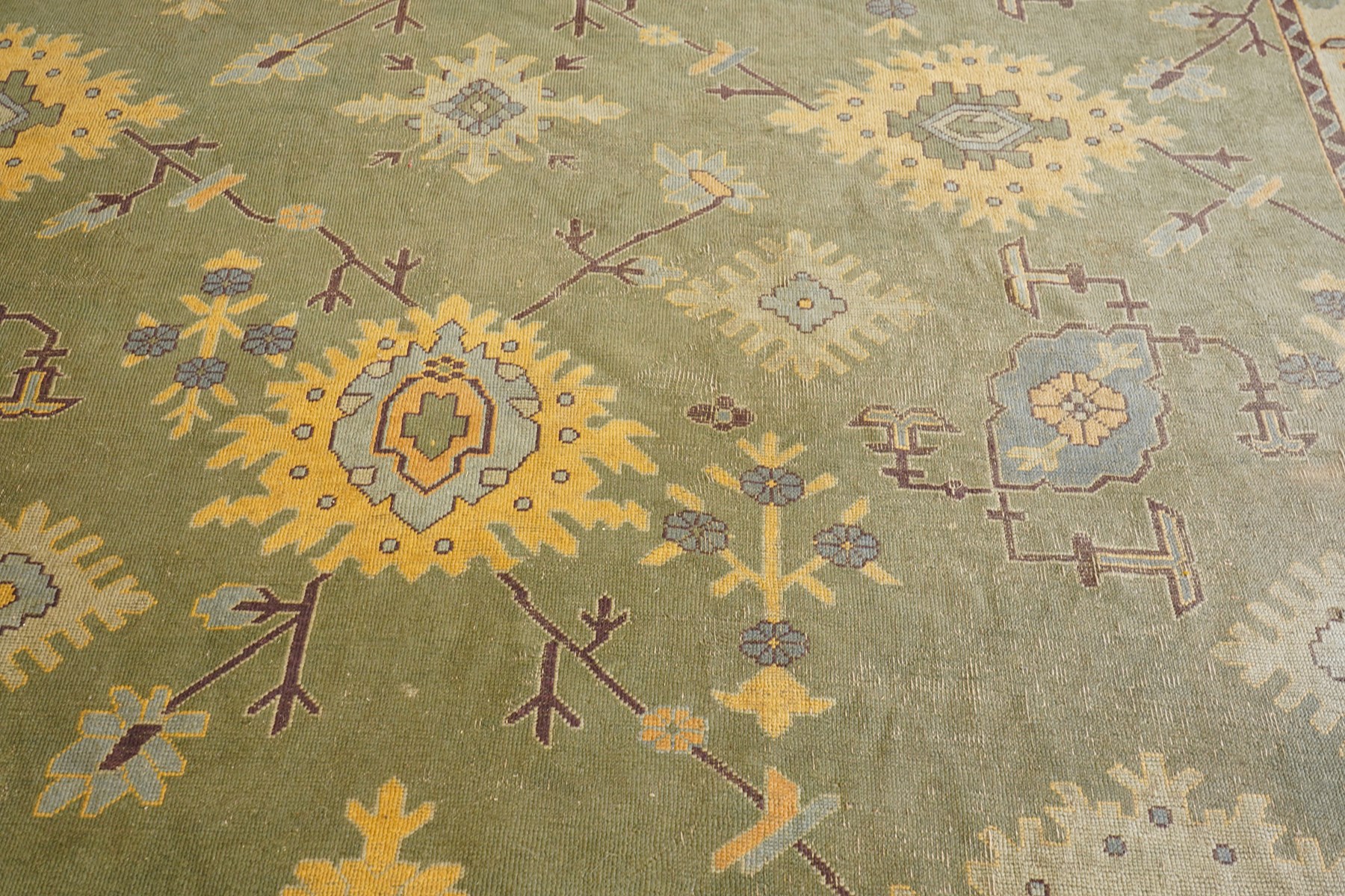 Lage Turkish Oushak green ground carpet, the field decorated with large stylised plant motifs and geometric design, the sage green guard band with further repeating foliate motifs