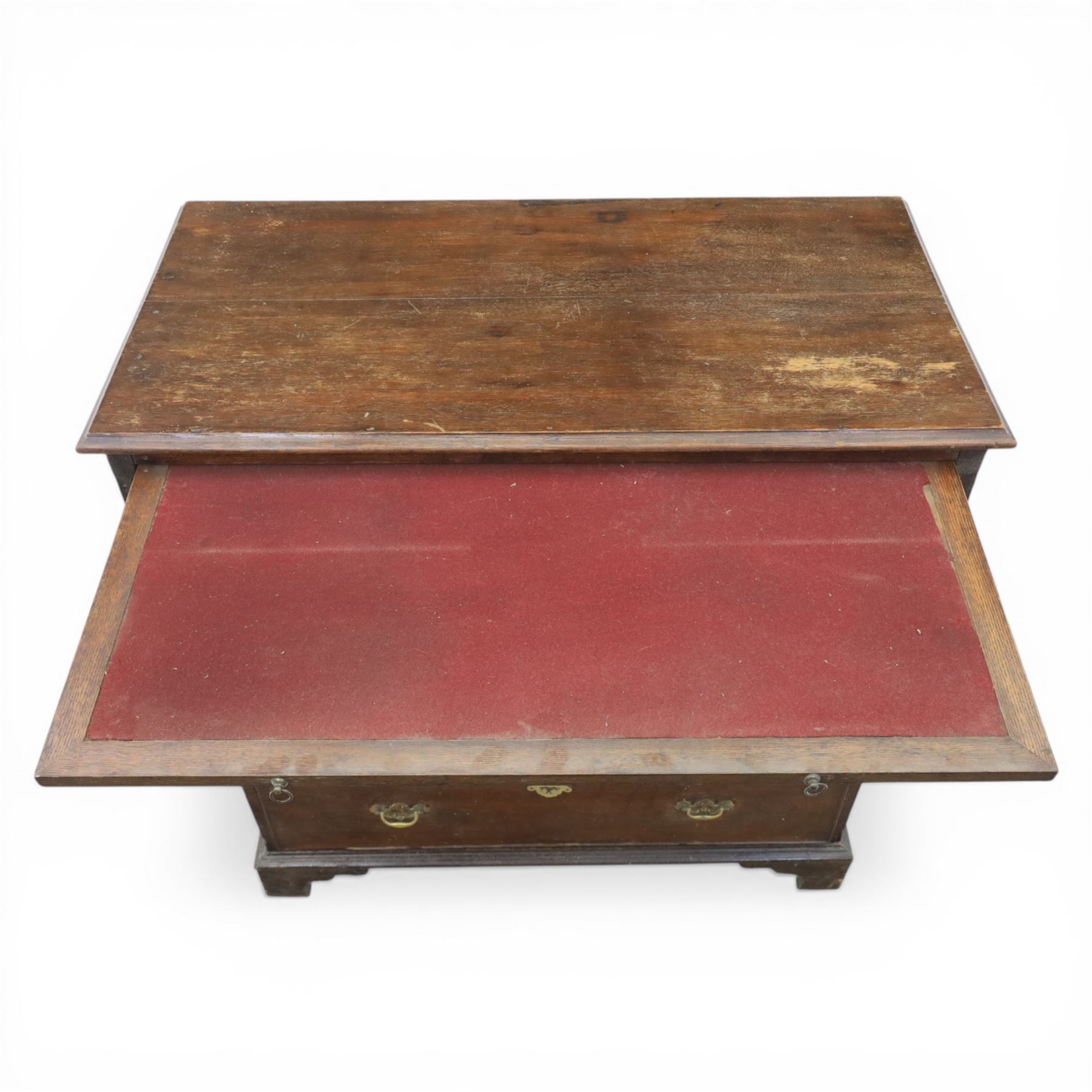 18th century oak chest, rectangular top with moulded edge, fitted with five drawers and baize line slide, with swan neck brass handles, raised on bracket feet