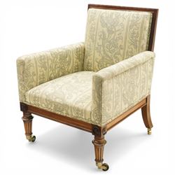 William IV rosewood framed library armchair, squared form with green on ivory ground upholstery, moulded lower seat rail with applied roundels over reeded supports, terminating to brass cups and castors