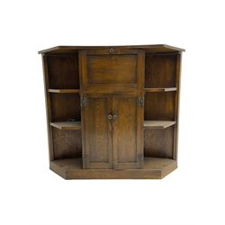 Early 20th century oak bow-front bar, the front uprights carved with lozenges and geometric decoration, the reverse fitted with fall-front drinks cabinet over double cupboard, flanked by four open shelves; together with circular seat bar stool ,(W31cm H65cm)