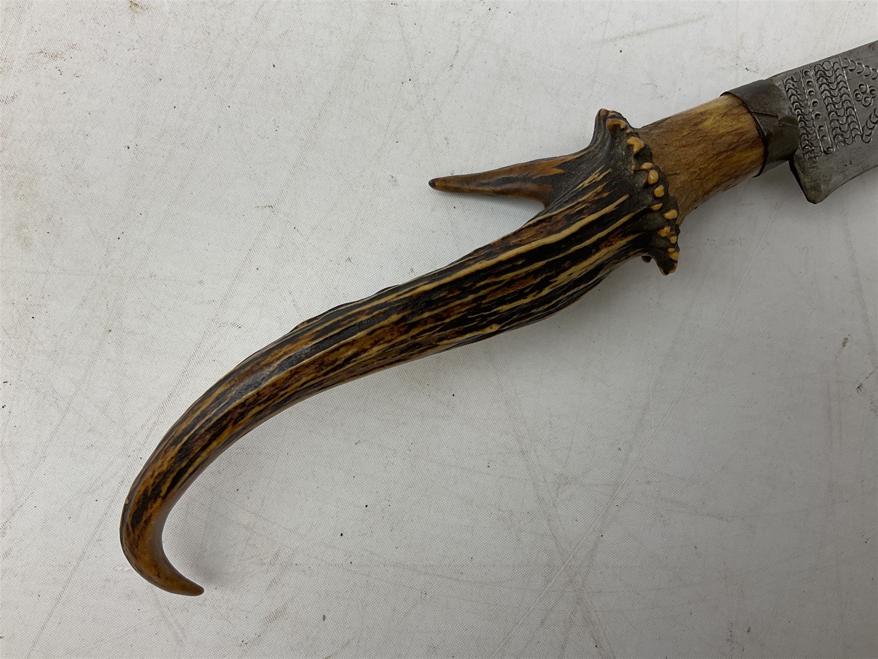 African tribal knife, possibly Shona Zimbabwe, the 22cm steel blade with all over punched decoration and antler handle; in inlaid and banded hardwood scabbard with two apertures L42cm overall