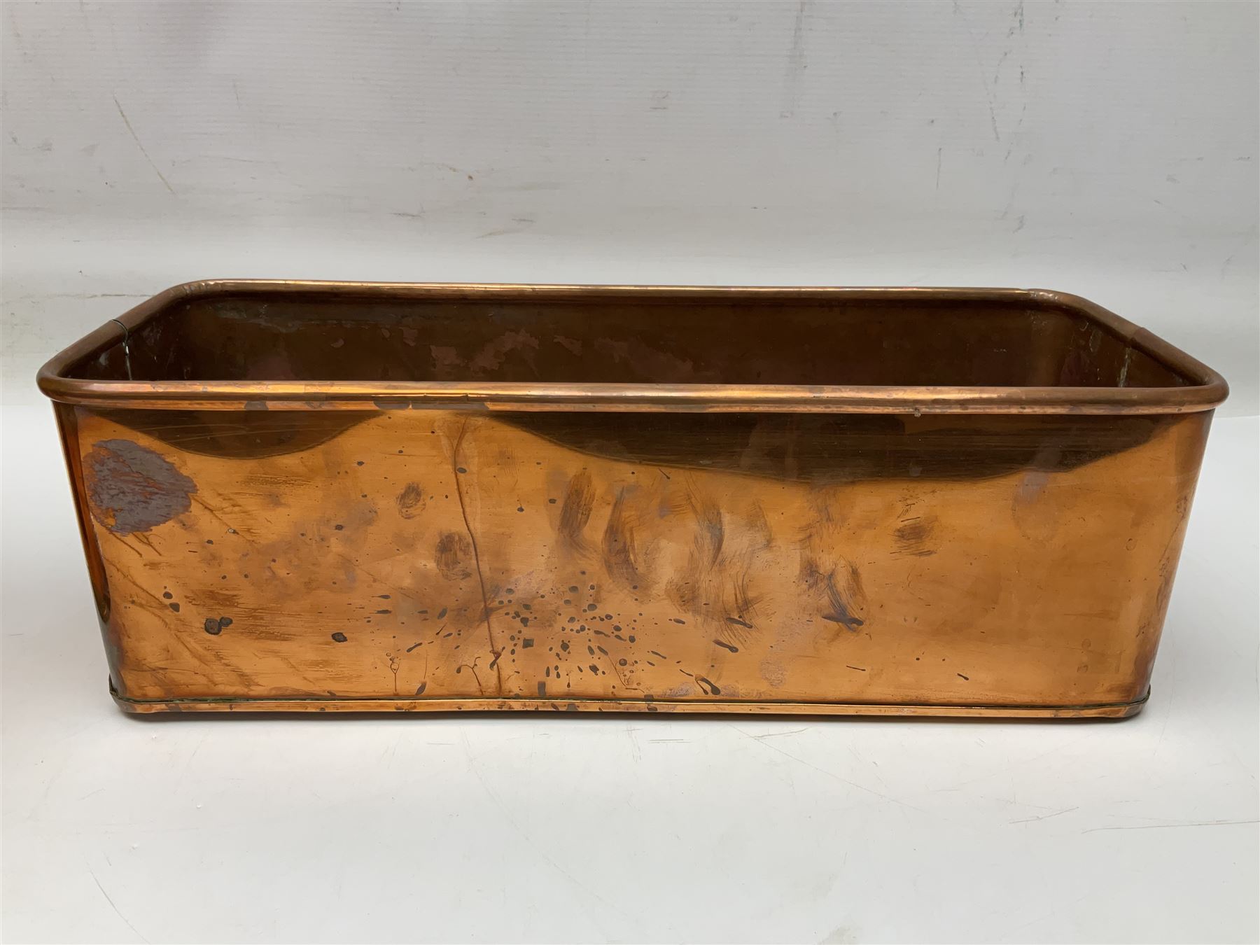 Victorian copper hot water urn, the body of plain cylindrical form with brass tap, the slightly domed lid with brass finial, together with a rectangular copper planter, with twin brass lion mask handles, urn H35cm