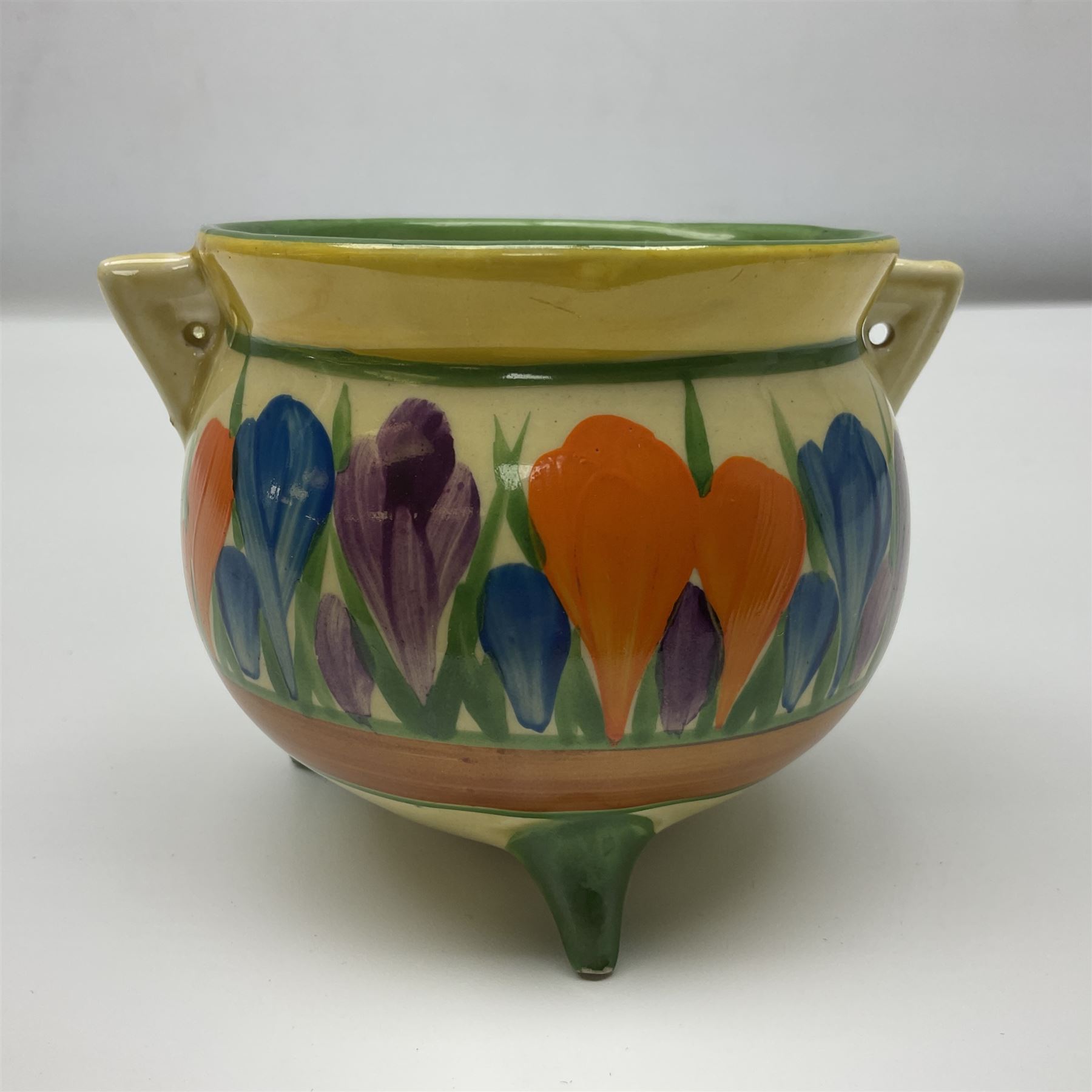 Clarice Cliff Bizarre for Newport Pottery, small bowl in the form of cauldron painted in the Crocus pattern, bordered by brown and yellow banding, with angular handles and raised upon three peg feet, with green printed mark and painted CROCUS beneath, circa 1929, H7cm