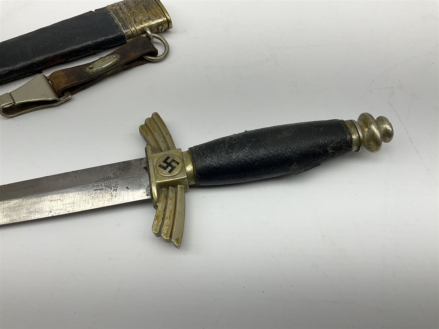  WW2 German SMF Solingen DLV flyers dagger with 16cm steel blade, nickel downswept cross-piece and pommel and leather covered grip, in leather and nickel scabbard with leather suspension strap L34cm overall. After WWI Germany was forbidden an air force by the Treaty of Versailles however the Deutscher Luftsport-Verband (German Air-sport Association) was formed in March 1933 from various sports flying clubs and had branches for aeroplane, gliding and balloon flying. Under cover of the sporting DLV, many future Luftwaffe pilots trained to fly. DLV was embodied with the NSKK in March 1935 and 1st March 1937 Luftwaffe formed.