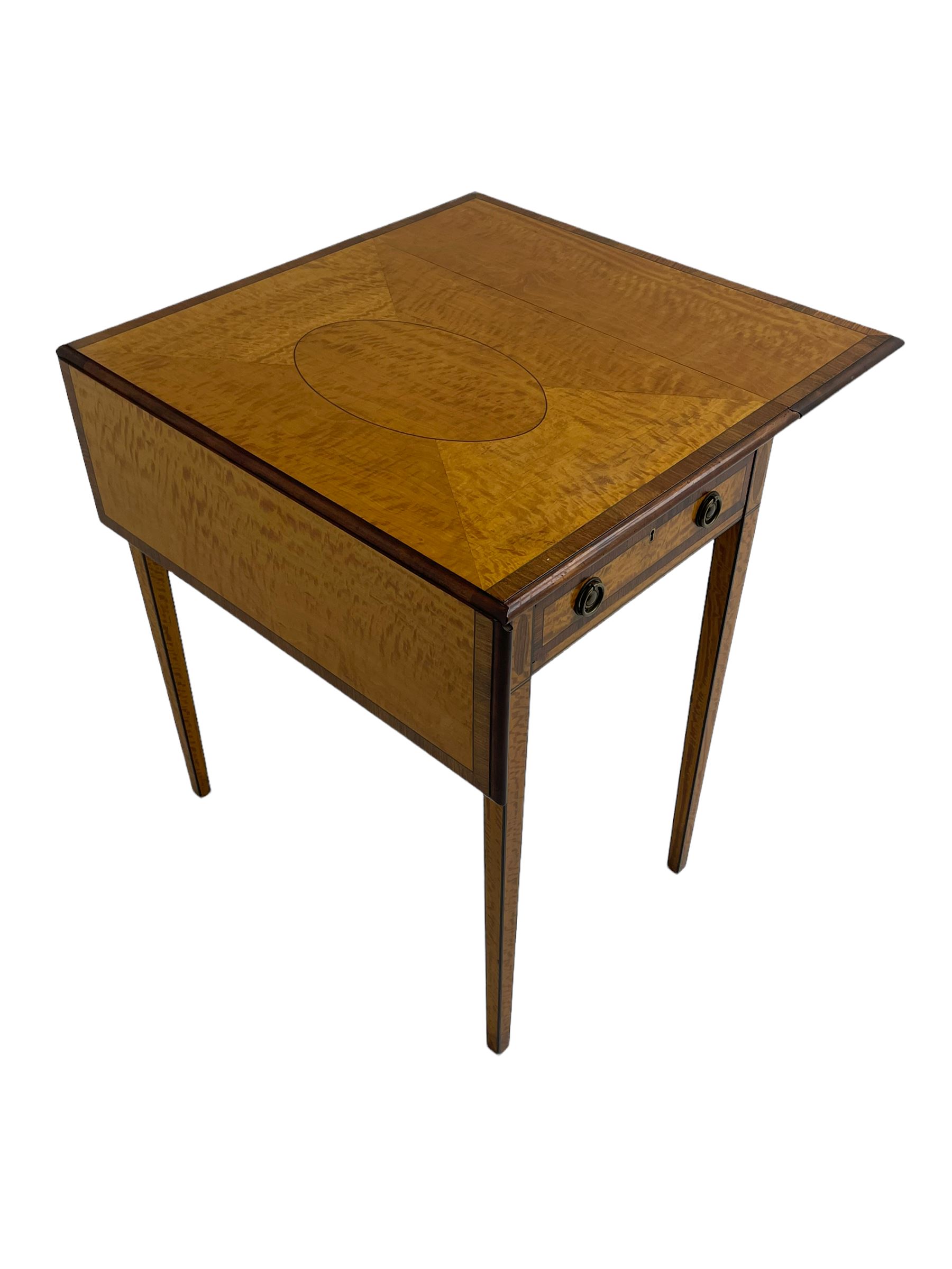 Mid-to-late 20th century Sheraton style satinwood Pembroke table, the drop leaf top with segmented veneers and central oval panel with ebony stringing, crossbanded in rosewood and with edge moulding, single short drawer to one end and faux drawer to other, square tapering supports