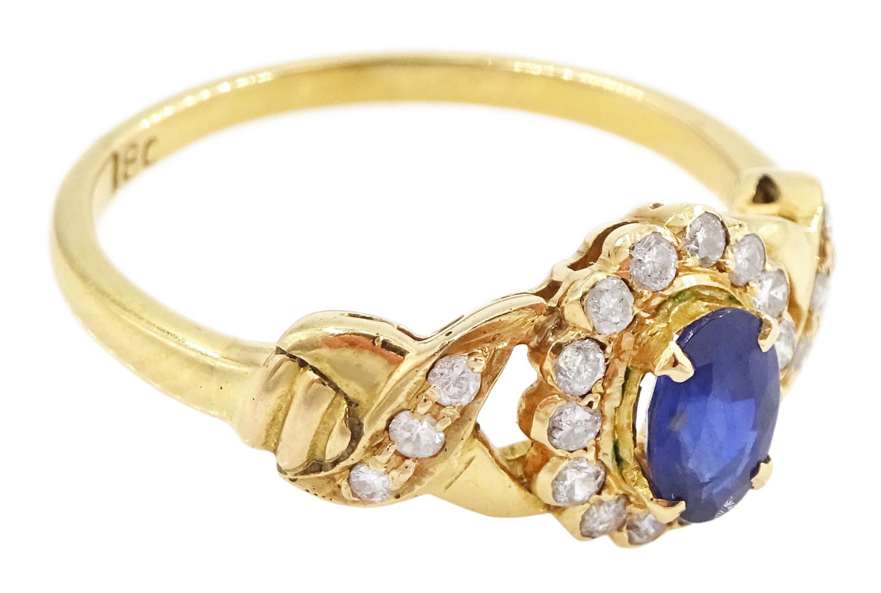 18ct gold sapphire and diamond cluster ring, single oval cut sapphire of approx 0.50 carat, surrounded by fourteen round brilliant cut diamonds, with pierced crossover diamond set shoulders, stamped, total diamond weight approx 0.20 carat
