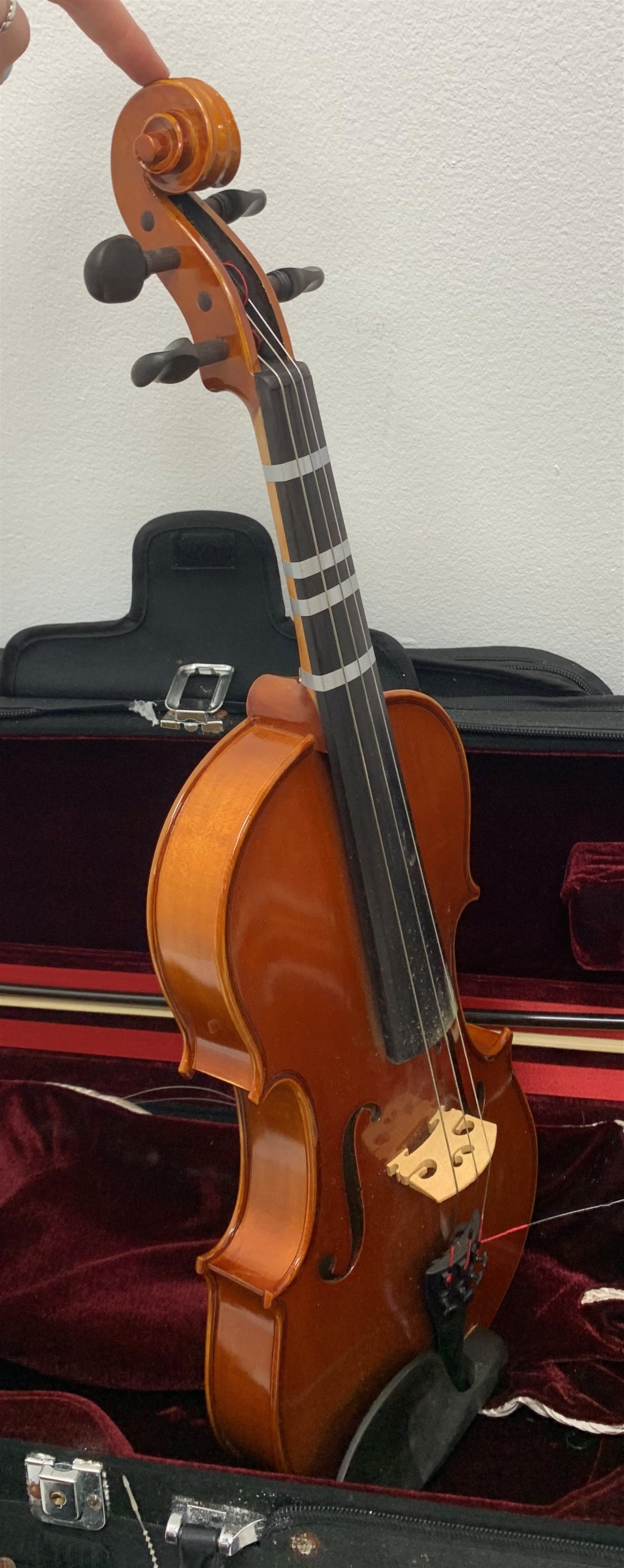 Three modern graduated violins - Suzuki 1/10 size child's violin with 23.5cm single piece back, bears label serial no.94282, 40cm overall; copy of Antonius Sradivarius of Cremona violin dated 1998 with 28cm two-piece back, 47cm overall; and Strobel violin with 35.5cm two-piece back, bears label dated 2006, serial no.512801325, 59cm overall. All cased with bows (3)