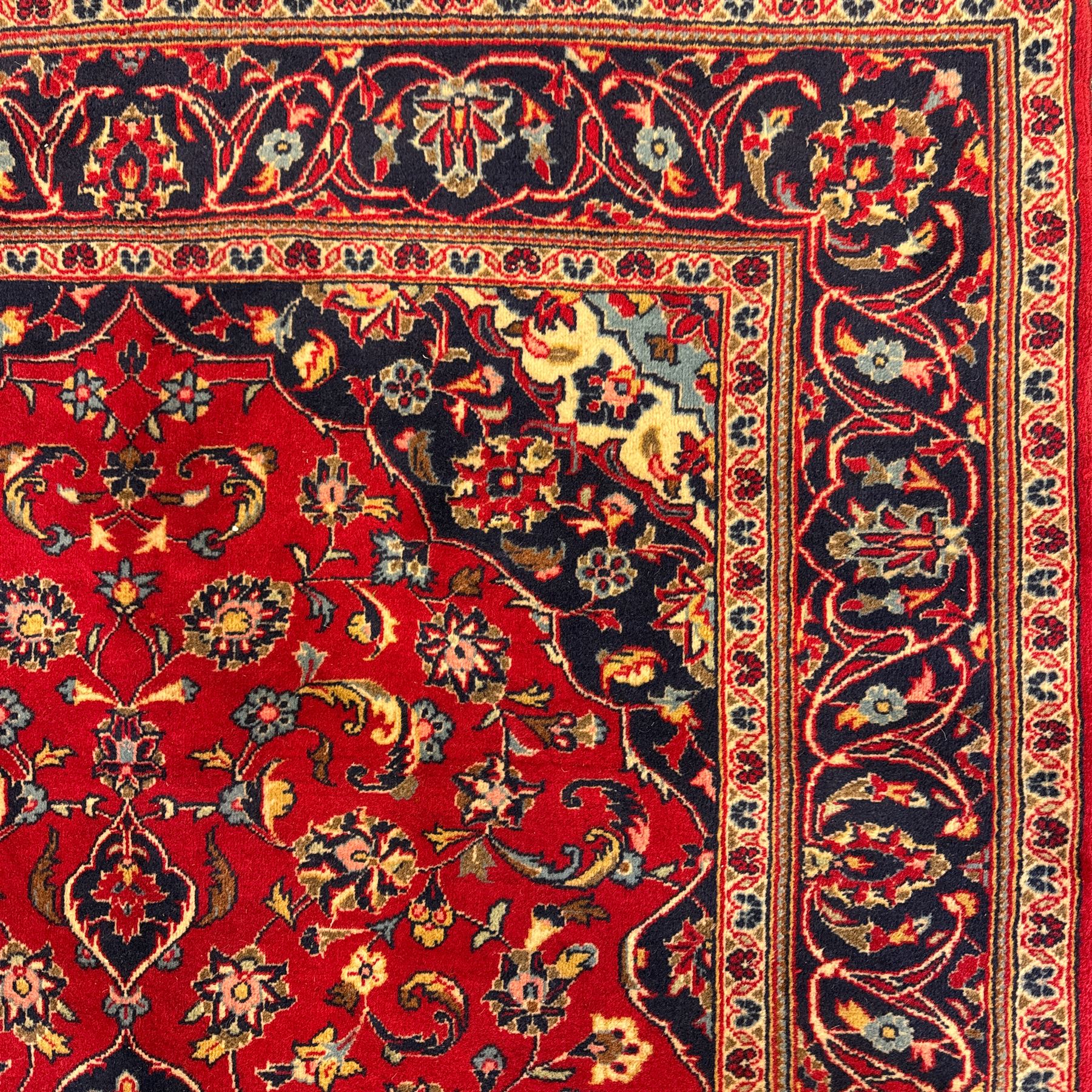 Central Persian Kashan rug, crimson ground with central medallion with  quarter medallions in each corner and decorated with floral sprays and palmettes, dark blue main border with repeating palmette and vine pattern   framed by small guard border with floral meanders 