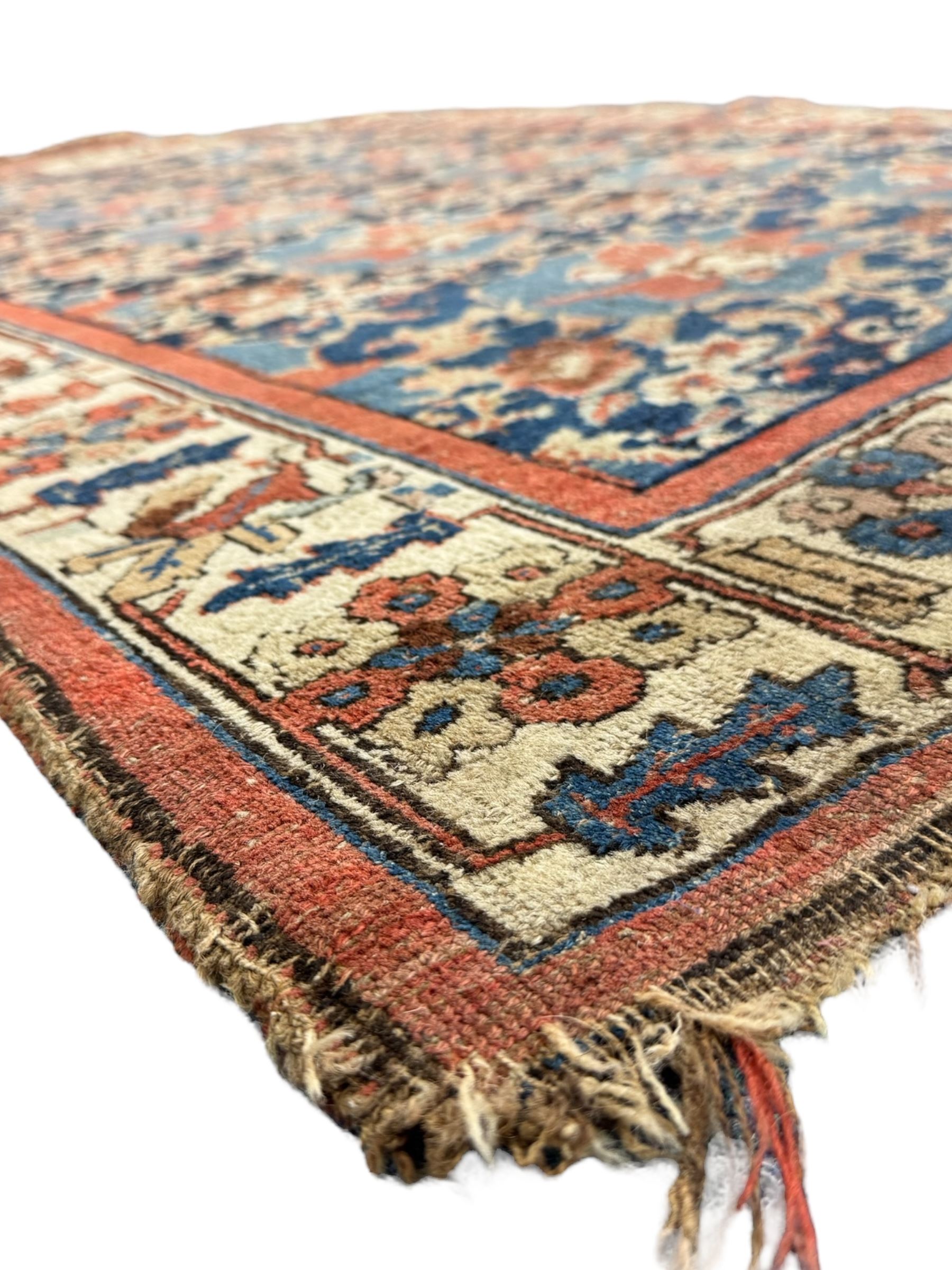 Persian Bidjar indigo ground rug, the busy field decorated with large floral motifs, the guarded ivory border adorned with repeating flower heads and stylised leaves