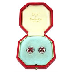 Pair of 18ct white and yellow gold Burmese ruby and diamond stud earrings, each cluster with five oval and round cut rubies and round brilliant cut and tapered baguette cut diamonds, total ruby weight approx 3.40 carat, total diamond weight approx 2.25 carat, in fitted box by Licht & Morrison, London