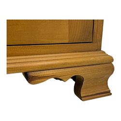 Pine chest of drawers topped with carved pediment with acorn and oak leaf motif, fitted with two short over three long drawers, standing on shaped apron base (W92, D46, H97cm); pine bedside cabinet, single drawer above paneled cupboard door enclosing open storage, shaped plinth base (W43, L32, H67cm)