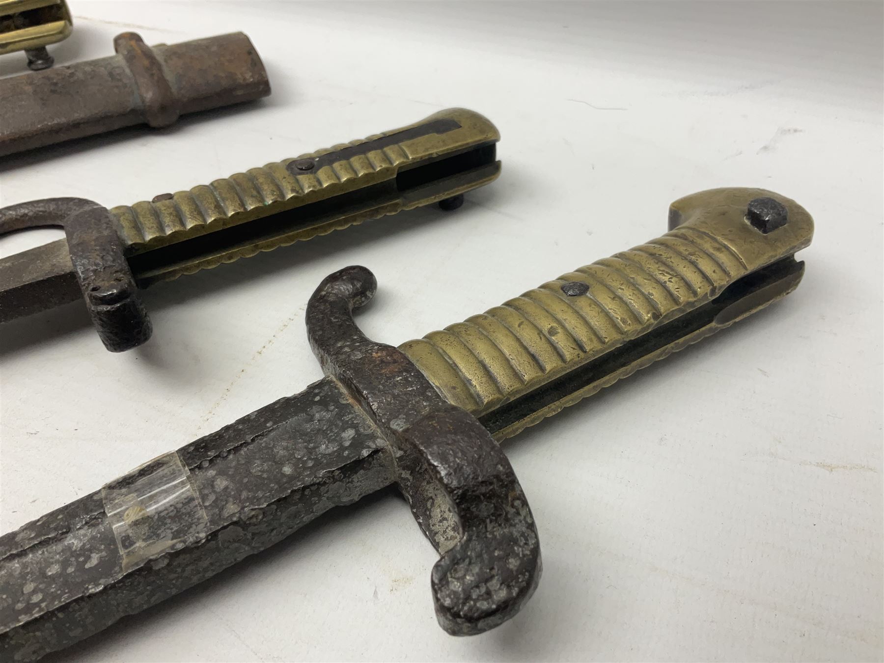 French Model 1874 Epee bayonet marked Oulle 1876 in associated scabbard; Model 1866 sabre bayonet in cut-down sword scabbard; and Model 1842/59 sabre bayonet in relic condition (3)