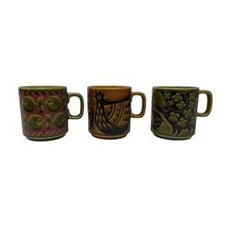 Thee Hornsea pottery mugs, one decorated with fish on a green ground, the second chickens on a brown grounds and the third pigs on a green ground (3)
