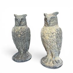 Pair of large composite stone garden statues modelled as standing horned owls, raised on c...