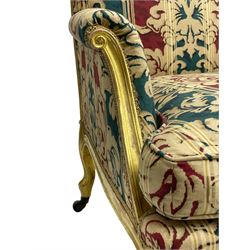 William Bertram & Son of London - pair late 19th century giltwood armchairs, moulded frame with scroll carved back and arm terminals, upholstered in striped fabric with foliate pattern, on shell carved cabriole supports, the brass castors stamped 